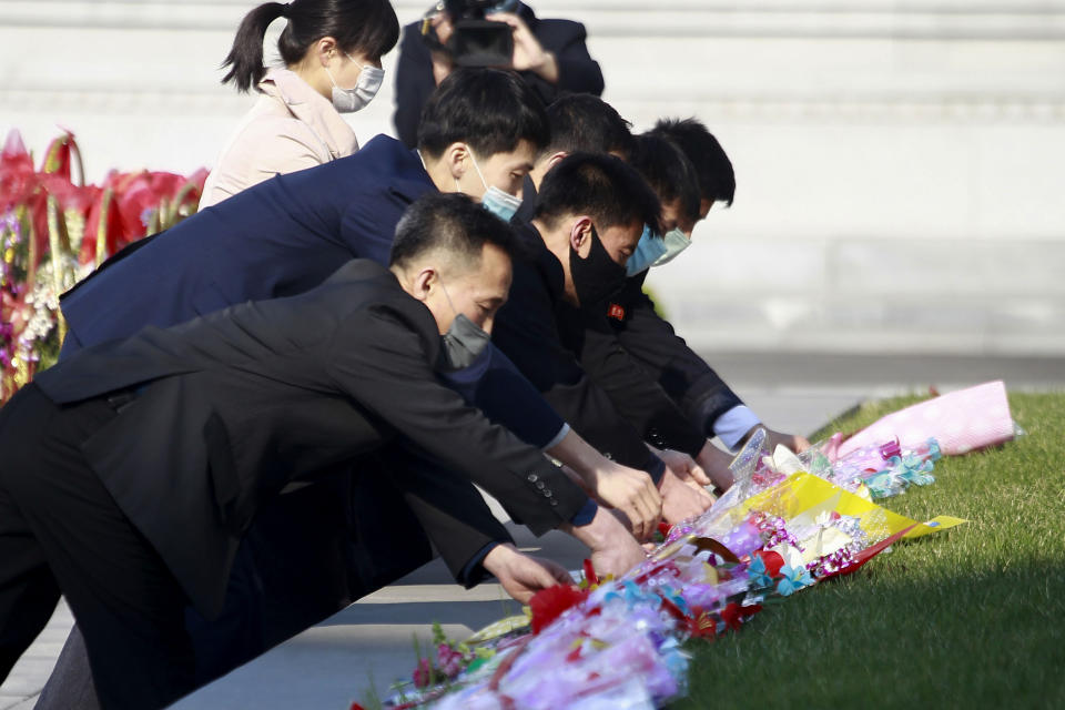 People lay bouquets of flowers at the statues of late North Korean leaders, Kim Il Sung and Kim Jong Il in the Mansudae Art Studio in the celebration of 110th birth anniversary of the state founder Kim Il Sung, in Pyongyang, on Friday, April 15, 2022. (AP Photo/Cha Song Ho)