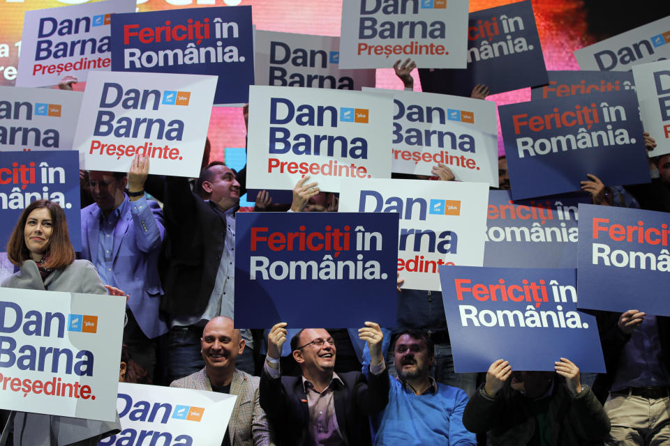 In this Thursday, Nov. 7, 2019, supporters of Dan Barna, the presidential candidate of the USR-Plus Alliance, hold banners before his speech at a rally in Bucharest, Romania. Romania will hold presidential elections on Nov. 10, 2019. Banners read "Happy in Romania". (AP Photo/Vadim Ghirda)