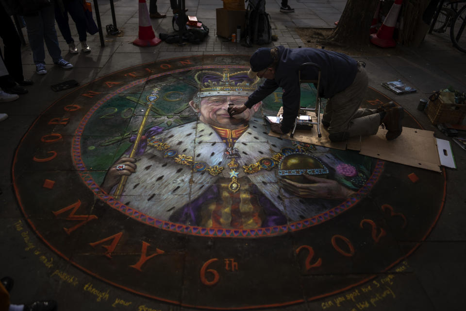 FILE - British Artist Julian Beaver gives the finishing touches to his work based on an image of King Charles III in London, Thursday, May 4, 2023. The Coronation of King Charles III will take place at Westminster Abbey on May 6. A year after the death of Queen Elizabeth II triggered questions about the future of the British monarchy, King Charles III’s reign has been marked more by continuity than transformation, by changes in style rather than substance. (AP Photo/Emilio Morenatti, File)