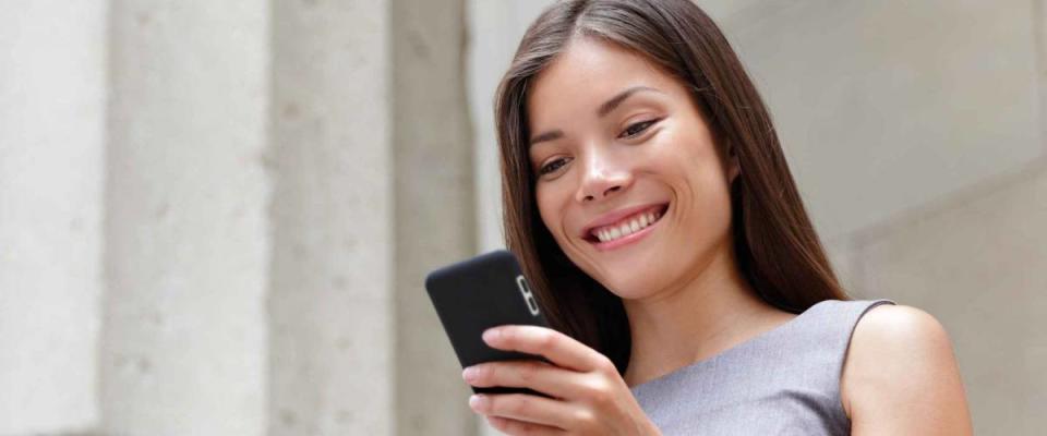 Young smart professional woman checking stocks on her smartphone.