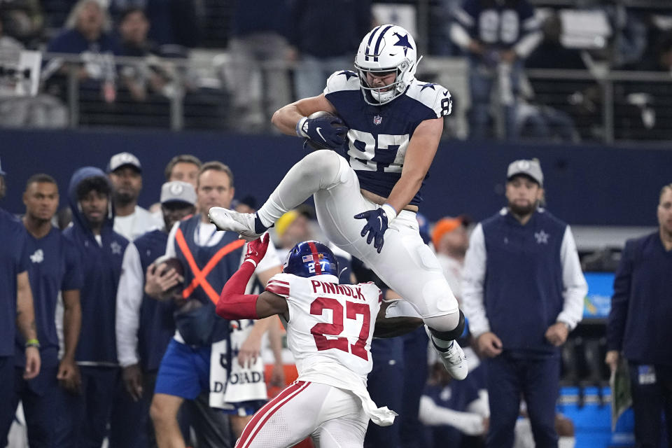 Dallas Cowboys tight end Jake Ferguson (87) leaps over New York Giants cornerback Jason Pinnock (27) during the second half of an NFL football game Thursday, Nov. 24, 2022, in Arlington, Texas. (AP Photo/Tony Gutierrez)