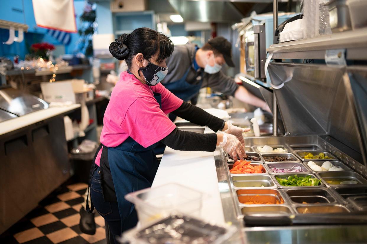 Michelle Olivera prepares lunch orders at Spoodles Deli in Worcester Wednesday.