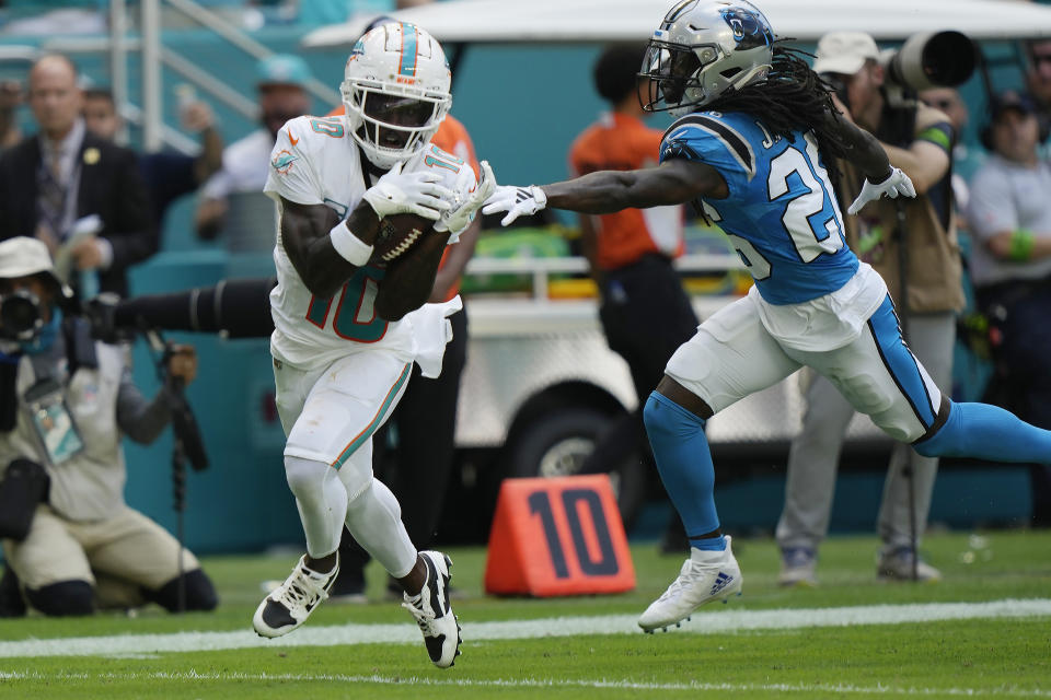 Miami Dolphins wide receiver Tyreek Hill (10) grabs a pass for a touchdown as Carolina Panthers cornerback Donte Jackson (26) is late with the tackle during the first half of an NFL football game, Sunday, Oct. 15, 2023, in Miami Gardens, Fla. (AP Photo/Lynne Sladky)
