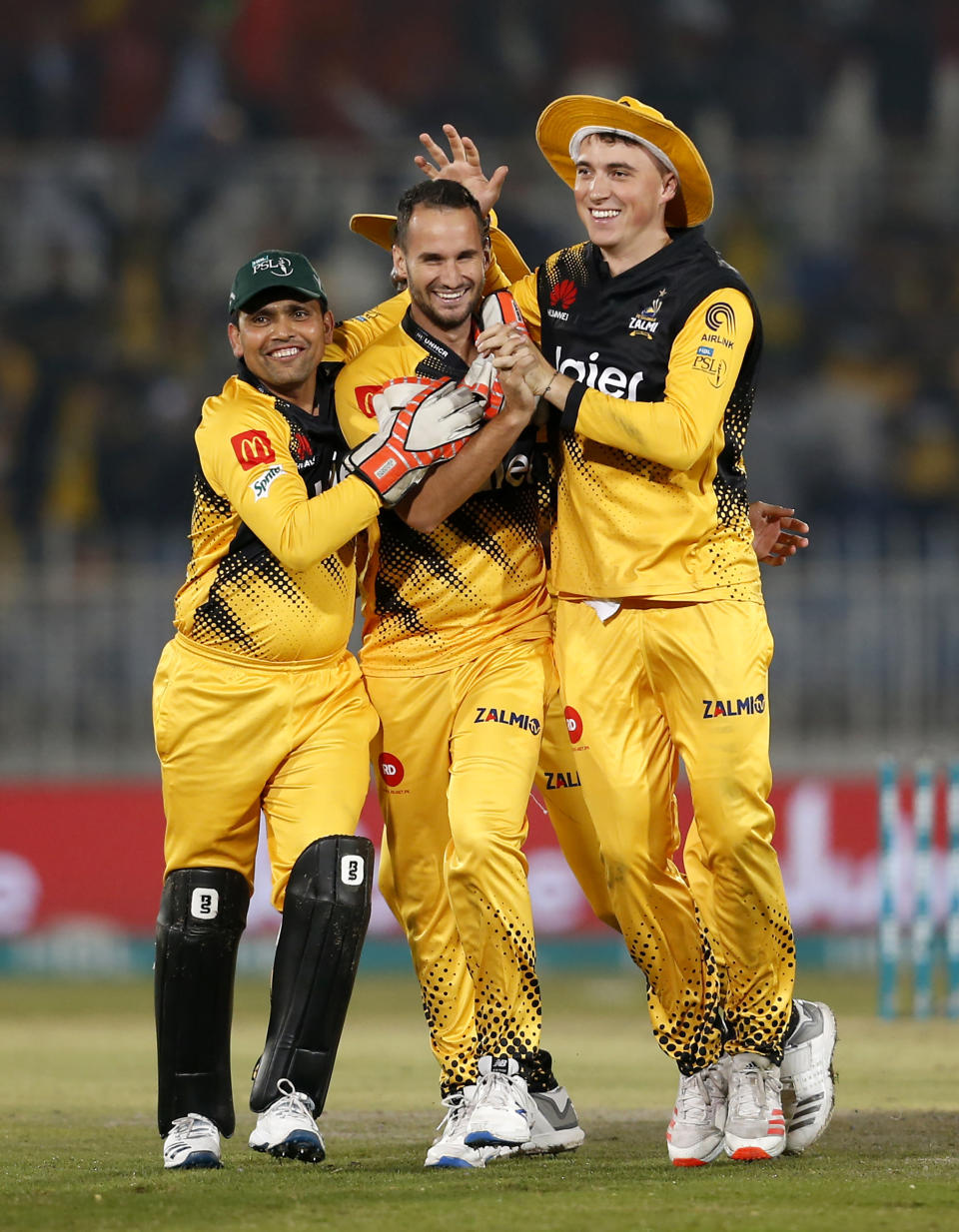 Peshawar Zalmi pacer Lewis Gregory, center, celebrates with teammates after taking the wicket of Lahore Qalandars batsman Sohail Akhtar during their Pakistan Super League T20 cricket match at Rawalpindi stadium in Rawalpindi, Pakistan, Friday, Feb. 28, 2020. (AP Photo/Anjum Naveed)