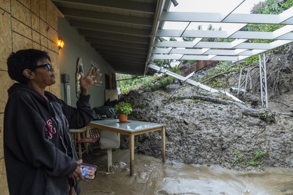 Home owner Dion Peronneau recounts, Tuesday, Feb. 6, 2024, how she was awoken by the sound of cracking around 4 a.m. Monday morning, Feb. 5, as a mudflow forced its way into her home early in the Baldwin Hills area of Los Angeles. (AP Photo/Damian Dovarganes)