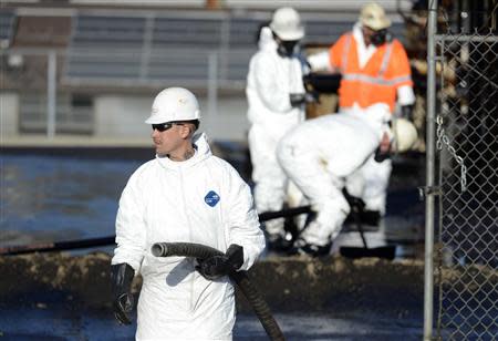 Workers clean up spilled oil at a facility in Los Angeles, May 15, 2014.REUTERS/Phil McCarten