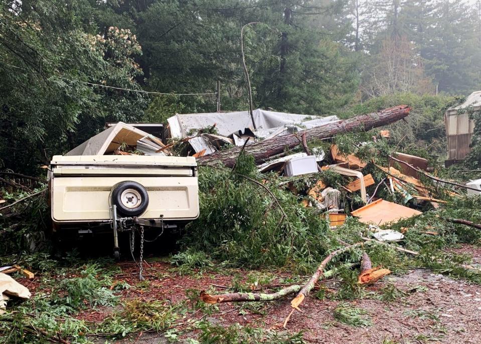 The wreckage of a home in a heavily forested area.