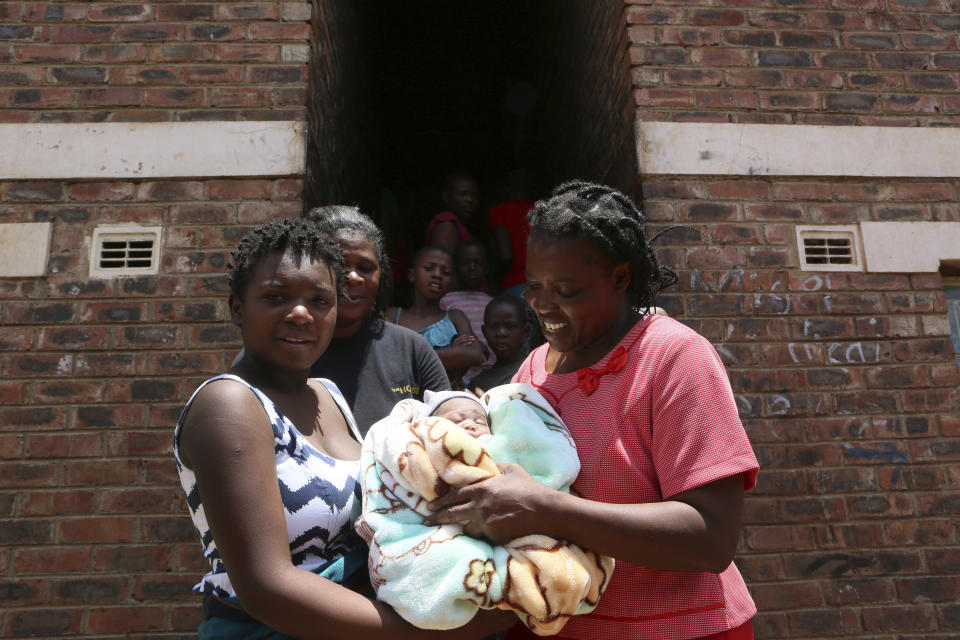 Perseverance Kanyoza, left, shows her newly delivered baby, after the birth in a tiny apartment in the poor suburb of Mbare in Harare, Zimbabwe, Saturday, Nov. 16, 2019. Kanyoza delivered a baby girl with the help of 72 year old grandmother Esther Zinyoro Gwena. Grandmother Esther Zinyoro Gwena claims to be guided by the holy spirit and has become a local hero, as the country’s economic crisis forces closure of medical facilities, and mothers-to-be seek out untrained birth attendants. (AP Photo/Tsvangirayi Mukwazhi)