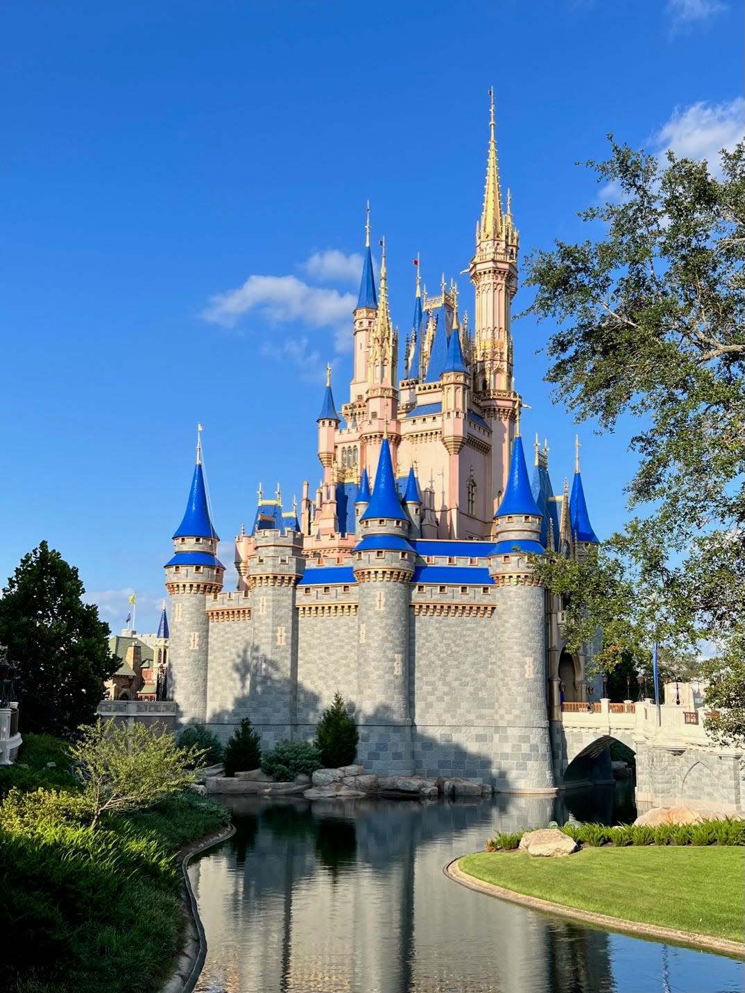 Cinderella Castle is reflected in the water at Disney World's Magic Kingdom.