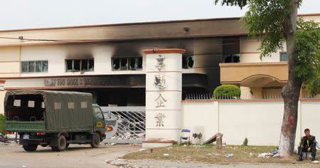 A riot police officer keeps guard outside the damaged Shining company building in Vietnam's southern Binh Duong province May 16, 2014. REUTERS/Stringer