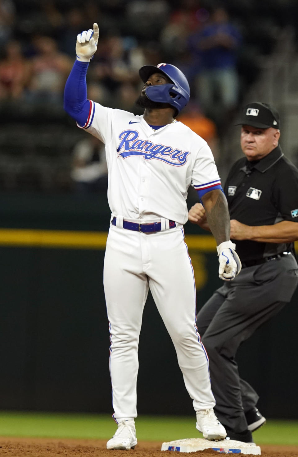 Texas Rangers' Adolis Garcia points up from second base after hitting an RBI double scoring teammate Corey Seager during the first inning of a baseball game against the Los Angeles Angels in Arlington, Texas, Monday, May 16, 2022. (AP Photo/LM Otero)