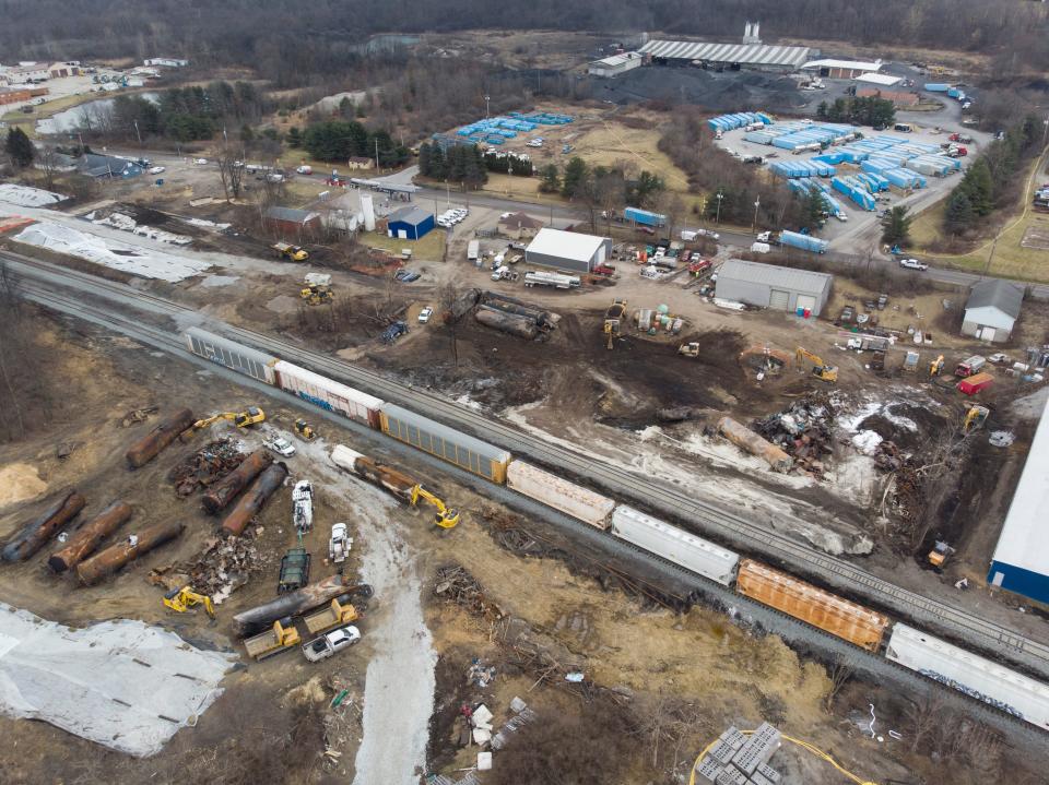 Feb 20, 2023; East Palestine, Ohio, USA;  A train passes by the wreckage of the Norfolk Southern train derailment in East Palestine as it is being cleaned up. Mandatory Credit: Adam Cairns-The Columbus Dispatch