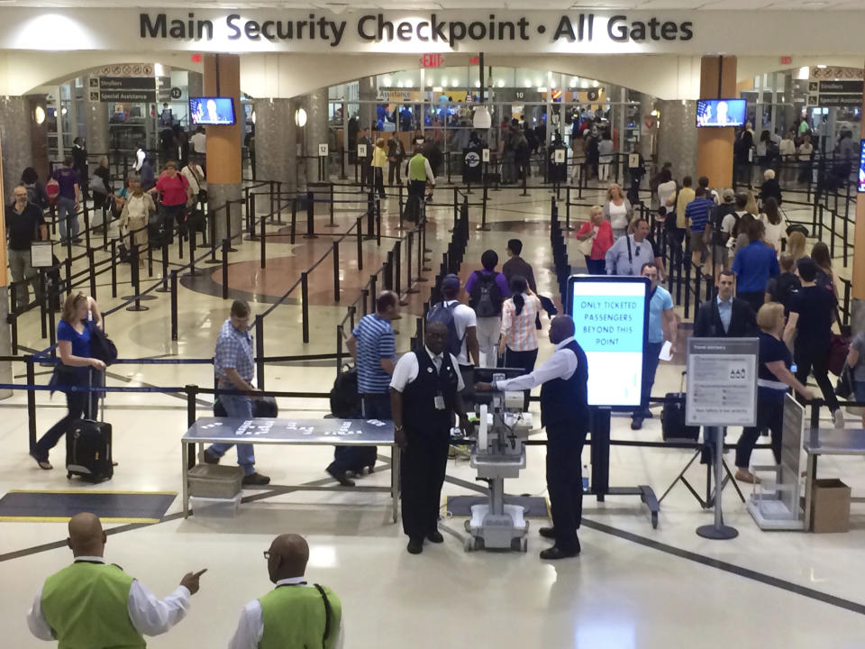 FILE - In this Friday, May 27, 2016, file photo taken from video, travelers pass through the main security gate at Hartsfield-Jackson Atlanta International Airport, in Atlanta. Authorities say a passenger awaiting a bag search at the Atlanta airport's main security checkpoint reached into the bag and grabbed a firearm, and it went off, causing chaos among travelers and prompting a temporary FAA ground stop on flights Saturday afternoon, Nov. 20, 2021, officials said. (AP Photo/Jeff Martin, File)