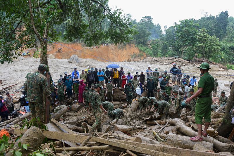 Rescuers and residents search for people who were missing after the landslide in Nam Tra My district