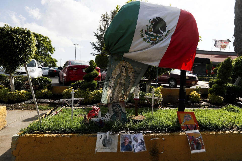 Photos of people who died in a metro collapse hang alongside a Mexican flag and images of Our Lady of Guadalupe, at the site of the now missing metro section in Mexico City, Wednesday, June 16, 2021. A June 16, 2021 preliminary report by experts into the collapse that killed 26 people placed much of the blame on poor welds in studs that joined steel support beams to a concrete layer supporting the trackbed. (AP Photo/Fernando Llano)