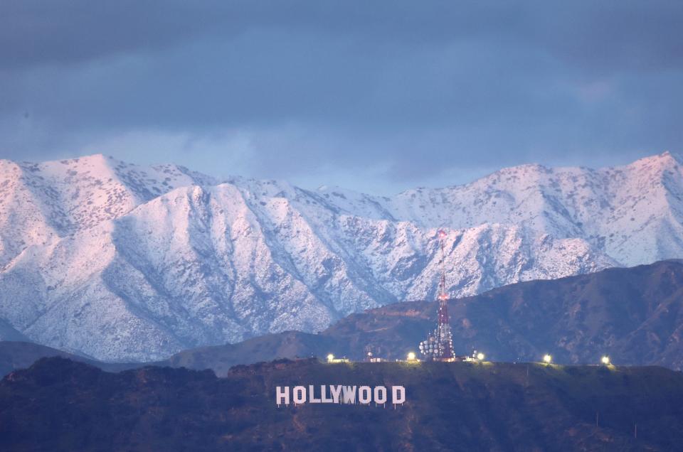 The Hollywood sign stands in front of snow-covered mountains after another winter storm hit Southern California on March 01, 2023 in Los Angeles, California.