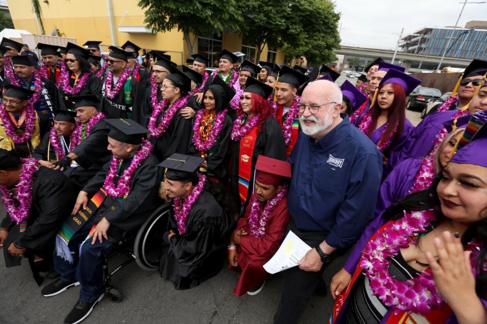 Father Greg Boyle stands with graduates during a celebration .