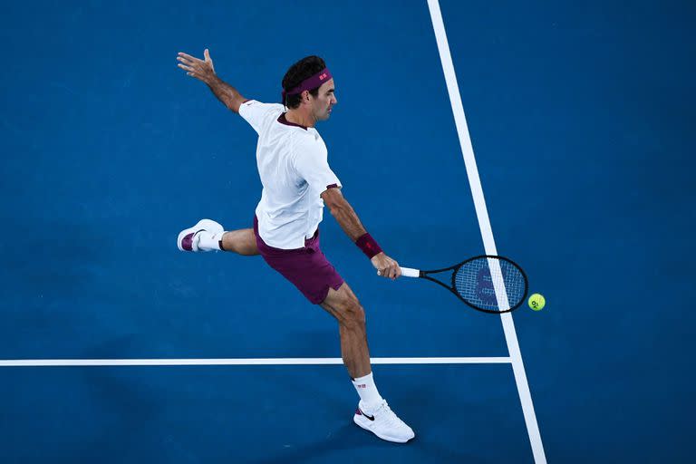 El 26 de enero de 2020, Roger Federer en devolución contra el húngaro Marton Fucsovics durante su partido individual masculino en el día siete del torneo de tenis del Abierto de Australia en Melbourne.