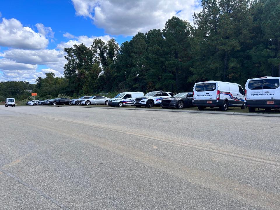 Fayetteville Police Department vehicles line up outside of the wooded area where skeletal remains were found in the 3900 block of Bragg Boulevard, Oct. 17, 2023.