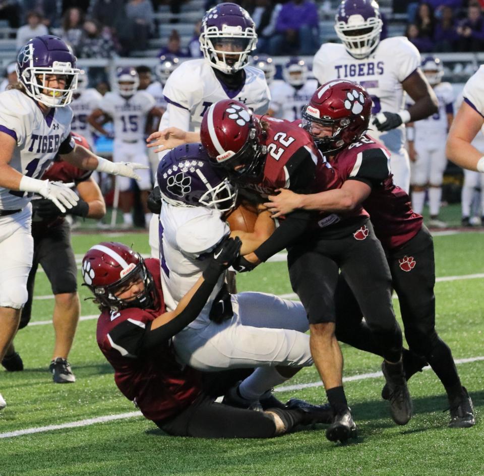 Newark sophomore Drayson Peterson (2) and seniors Max Durbin (22) and Calvin Untied (42) wrap up a Pickerington Central ball carrier at White Field on Friday, Sept. 23, 2022. The Wildcats fell 35-6 to the visiting Tigers.