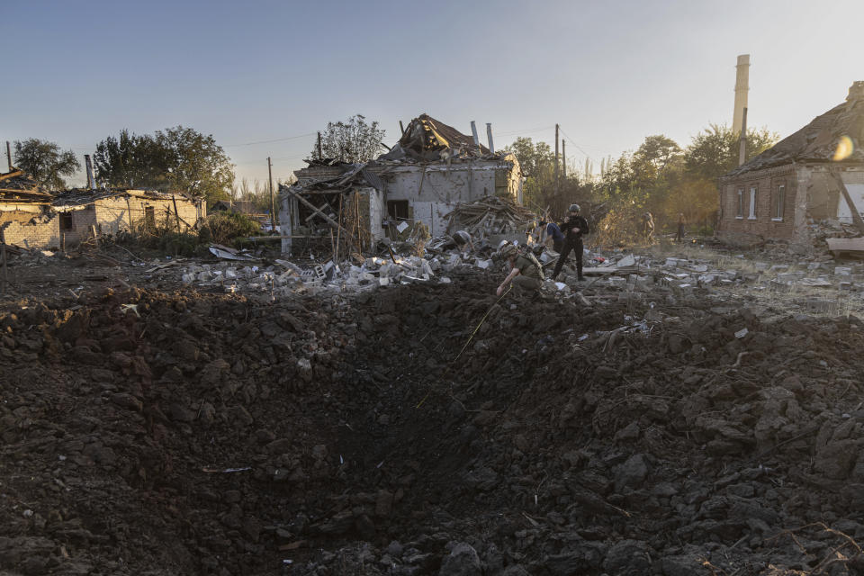 Police officers examine a crater from a Russian rocket at the residential neighbourhood in Kostiantynivka, Donetsk region, Ukraine, Wednesday, September 27, 2023. (AP Photo/Alex Babenko)