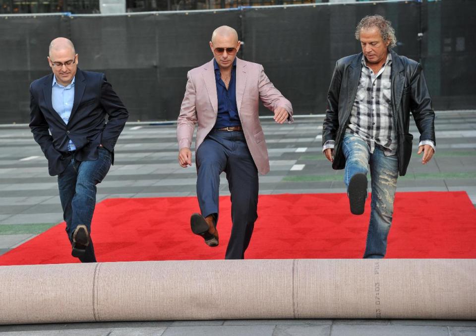 Mark Bracco, ABC's VP of alternative series and specials, from left, host Pitbull, and music producer Larry Klein attend the 2013 American Music Awards Red Carpet Rollout and Press Preview Day, Wednesday, Nov., 20, 2013, at the Nokia Theatre L.A. Live in Los Angeles. The awards will be held on Sunday. (Photo by Richard Shotwell/Invision/AP)