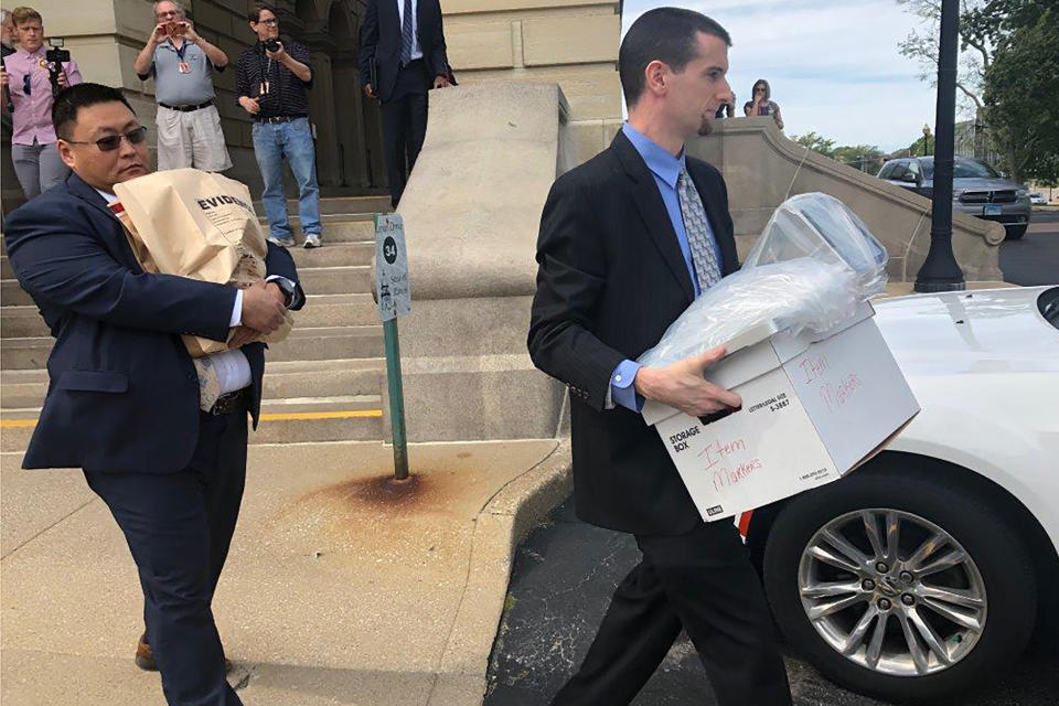 FILE - In this Sept. 24, 2019 file photo, men carrying boxes and a bag marked EVIDENCE leave the Illinois State Capital in Springfield Ill. Even the normally unflappable speaker of the Illinois House Michael Madigan had to pause at the sight of FBI agents entering the Democratic side of the Capitol building this week and later hauling away containers of documents from a lawmaker's office. The Capitol raid Monday was at the office of state Sen. Martin Sandoval, who represents a southwest side Chicago district that overlaps with Madigan's district. (AP Photo/John O'Connor, File)