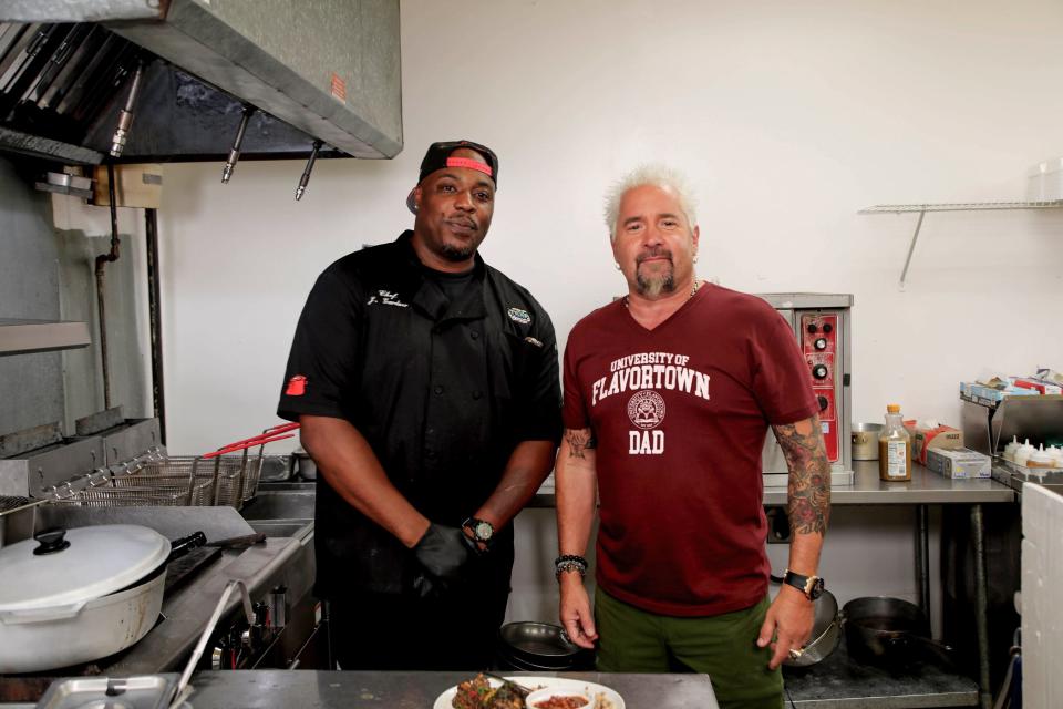 Guy Fieri in the kitchen with Chef-owner Jason Gardner at Trap Fusion in Memphis, Tennessee, as seen on Diners Drive-Ins and Dives, season 38.