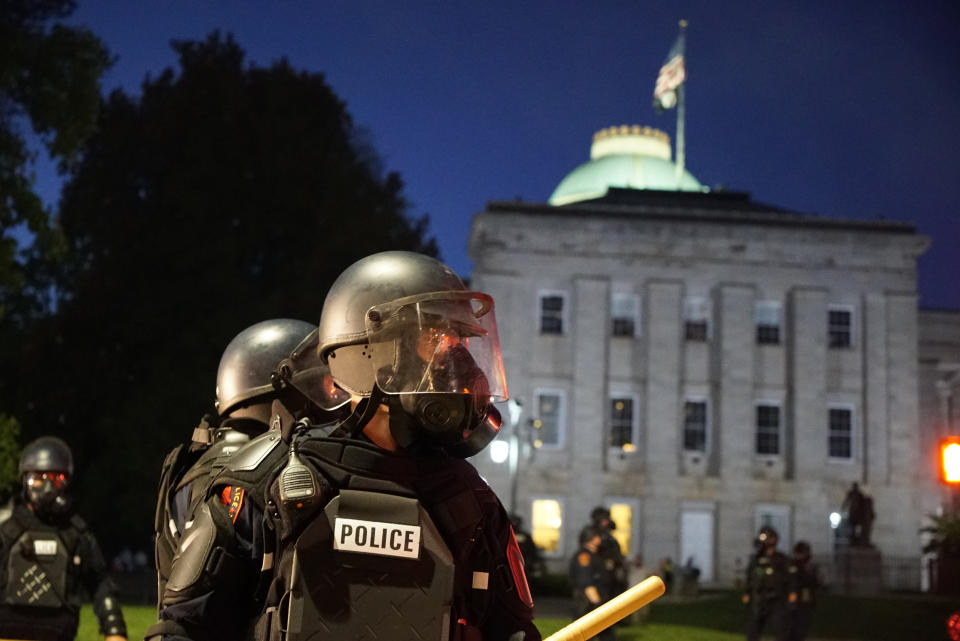 FILE - Police in riot gear protect the old state capitol building in Raleigh, N.C., on May 31, 2020. A North Carolina civil rights group filed a federal lawsuit on Tuesday, April 11, 2023, challenging a new state law that will increase punishments for violent protests in response to the nationwide 2020 racial injustice demonstrations ignited by George Floyd’s murder. (AP Photo/Allen G. Breed, File)