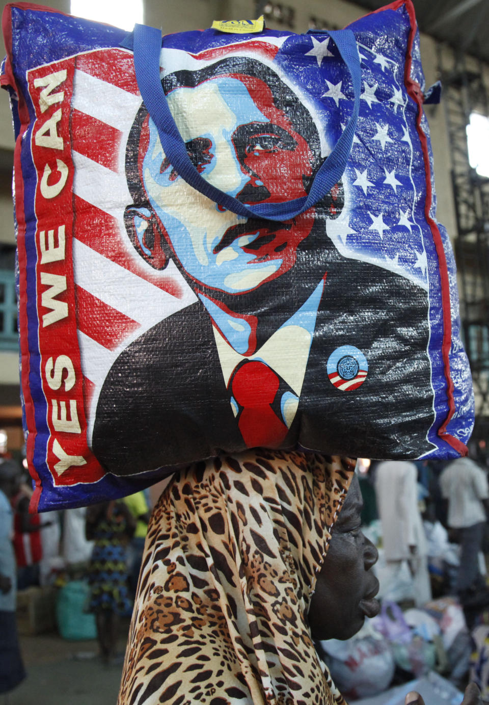 In this Photo taken, Friday, March . 15, 2013, A passenger balance a bag on her head with a portrait of U.S President Barrack Obama, as she wait to board a train to Kano, in Lagos, Nigeria. Nigeria reopened its train line to the north Dec. 21, marking the end of a $166 million project to rebuild portions of the abandoned line washed out years earlier. The state-owned China Civil Engineering Construction Corp. rebuilt the southern portion of the line, while a Nigerian company handled the rest. AP Photo/Sunday Alamba)