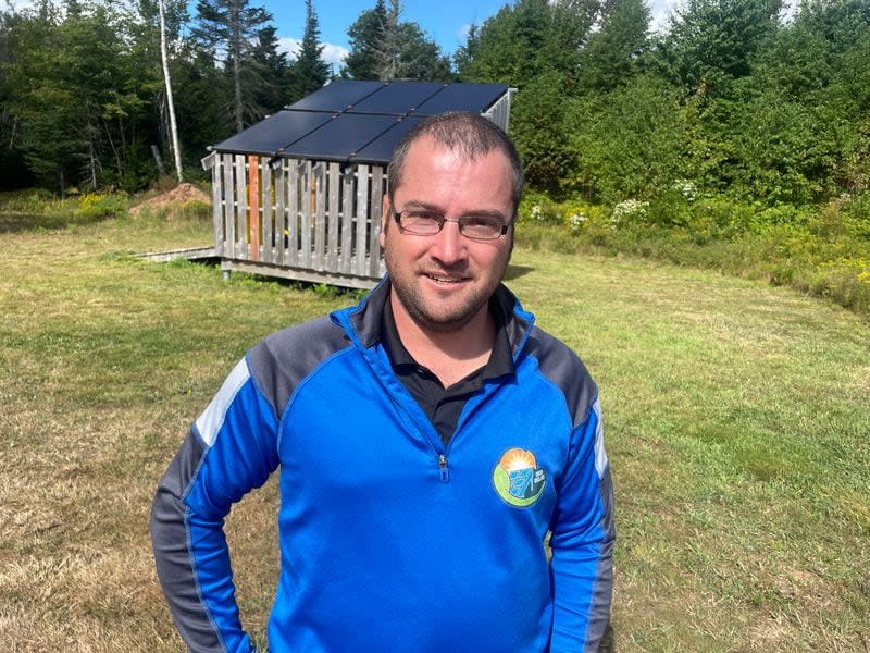 Andrew Walsh of WCD Solar stands in front of the solar-powered irrigation system at The Berry Orchard. 