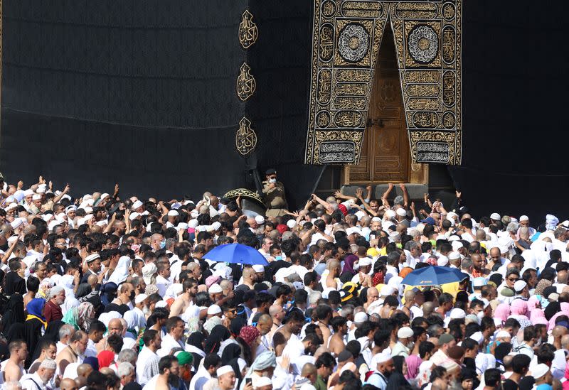 A police officer wears a face mask to prevent contracting coronavirus, as Muslim pilgrims pray at Kaaba in the Grand mosque in the holy city of Mecca