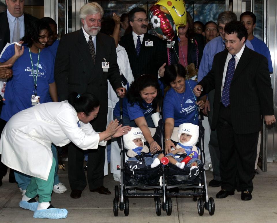 Clarence and Carl Aguirre are wheeled out of Montefiore Children's Hospital by Dr. James T. Goodrich, Arlene Aguire, Arlene's mom, Evelyn, and Dr. David Staffenberg. Aug. 30, 2004.  Goodrich died March 30, 2020, of complications from COVID-19.