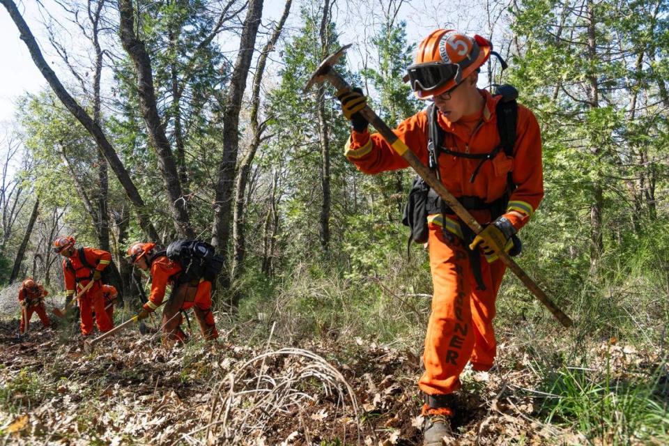 Cal Fire Inmate mentor Alexander Horn, 26, leads Crew 5 as it demonstrates its fire fighting skills in April by cutting a fire break at the Growlersburg Conservation Camp in Georgetown.