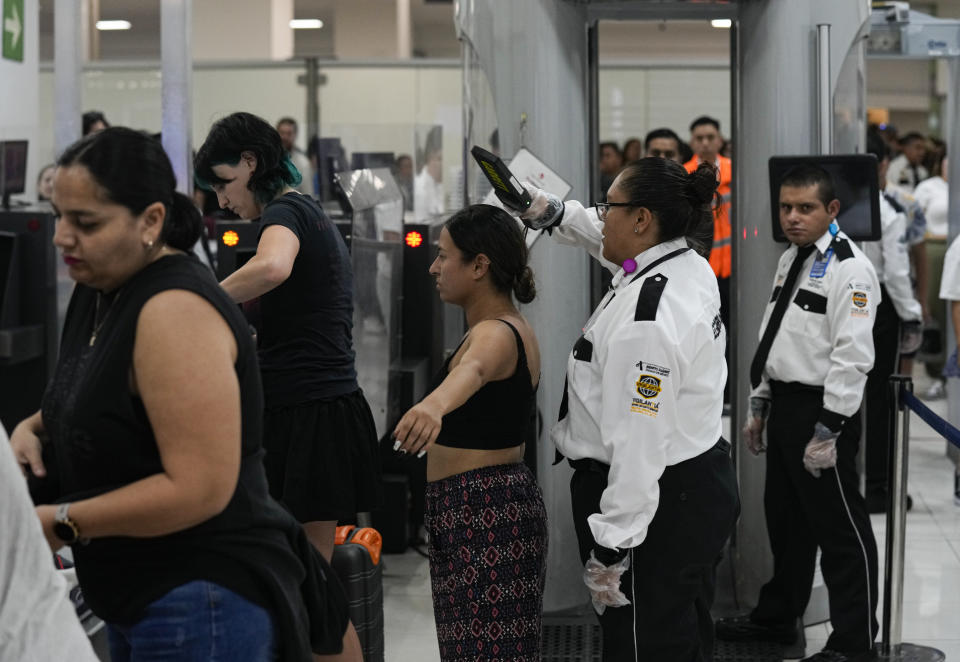 FILE - A private security officer checks a passenger at a check point at the Benito Juarez International Airport, in Mexico City, June 30, 2023. Some four million travelers move through through the airport each month. (AP Photo/Fernando Llano, File)