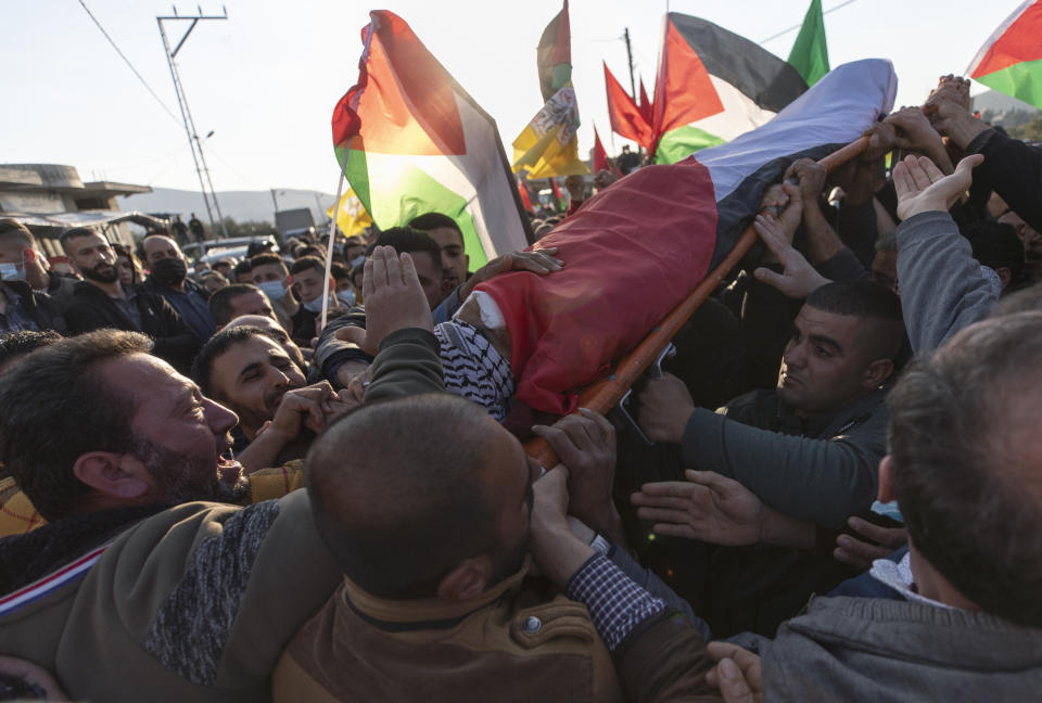 Palestinian mourners chant anti Israel slogans while carrying the body of Atef Hanaisheh, 45 during his funeral procession in the West Bank village of Beit Dajan, east of Nablus, Friday, March 19, 2021. The Palestinian Health Ministry said Israeli troops shot and killed a Palestinian protester during clashes in the occupied West Bank. (AP Photo/Nasser Nasser)