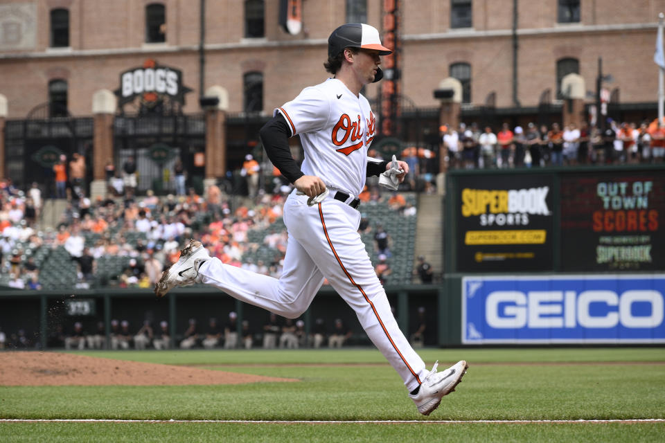 Baltimore Orioles' Adley Rutschman runs home to score on a sacrifice fly by Ryan Mountcastle during the first inning of a baseball game against the Texas Rangers, Sunday, May 28, 2023, in Baltimore. (AP Photo/Nick Wass)