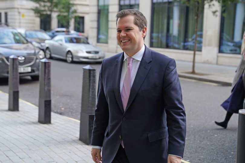 Conservative former minister Robert Jenrick walking in street smiling