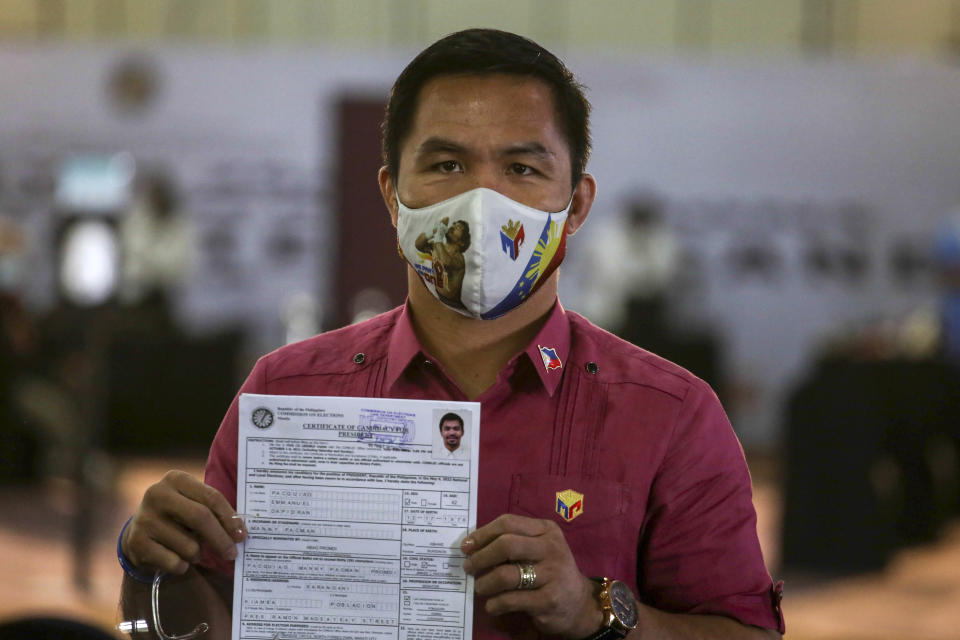 Retired Filipino boxing star and senator Manny Pacquiao shows his certificate of candidacy for next year's presidential elections shortly after filing before the Commission on Elections at the Sofitel Harbor Garden Tent in Manila, Philippines on Friday, Oct. 1, 2021. Friday marks the start of a weeklong registration period for candidates seeking to lead a Southeast Asian nation that has been hit hard by the pandemic and deep political conflicts.(Jam Sta Rosa/Pool Photo via AP)