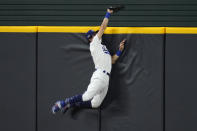 Los Angeles Dodgers' Cody Bellinger slams into the outfield wall and makes the catch as he robs San Diego Padres' Fernando Tatis Jr. of a home run on a deep drive during the seventh inning in Game 2 of a baseball National League Division Series Wednesday, Oct. 7, 2020, in Arlington, Texas. (AP Photo/Sue Ogrocki)