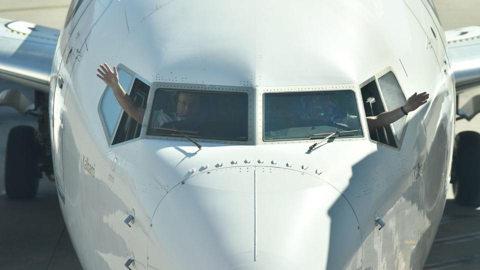 Piloten winken aus dem Cockpit einer Passagiermaschine der Fluggesellschaft Quantas.