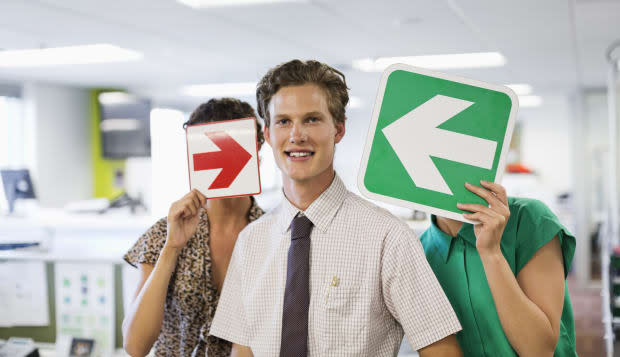 Business people holding arrows in office