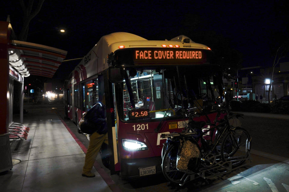 A man wears a mask to prevent the spread of coronavirus as he boards a city bus Tuesday, Nov. 24, 2020, in San Diego. California's health secretary urged people to say "no" to family and friends who want to gather for Thanksgiving, joining other officials in issuing dire warnings about the spread of the coronavirus. (AP Photo/Gregory Bull)