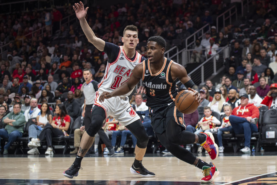 Atlanta Hawks guard Aaron Holiday, right, drives past Miami Heat guard Tyler Herro during the first half of an NBA basketball game, Monday, Jan. 16, 2023, in Atlanta. (AP Photo/Hakim Wright Sr.)