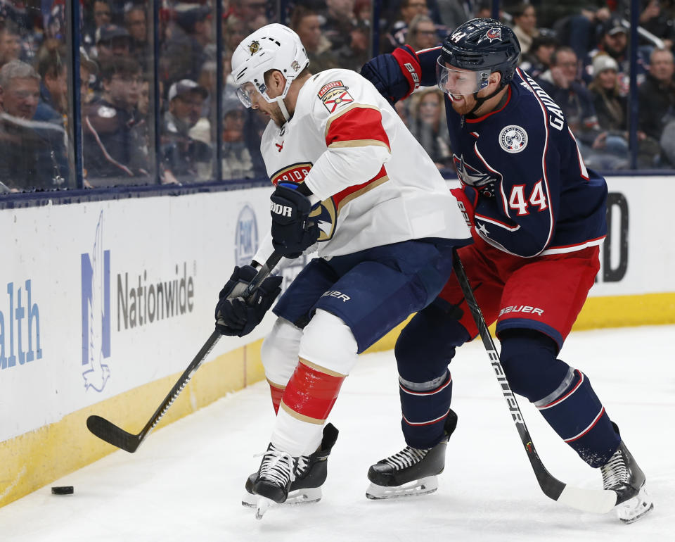 Florida Panthers' Colton Sceviour, left, and Columbus Blue Jackets' Vladislav Gavrikov, of Russia, vie for the puck during the first period of an NHL hockey game Tuesday, Dec. 31, 2019, in Columbus, Ohio. (AP Photo/Jay LaPrete)