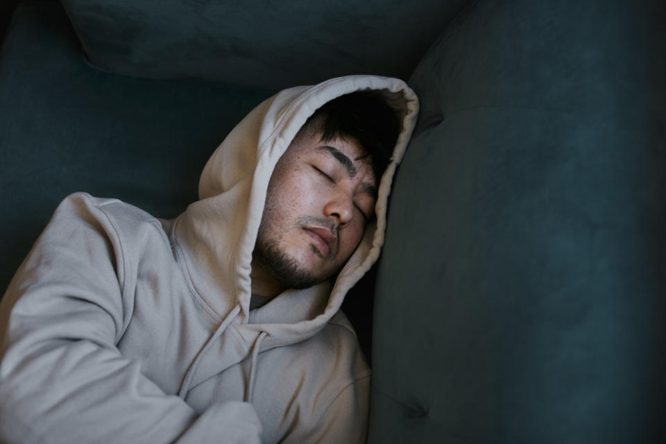 A man sleeps on a couch.