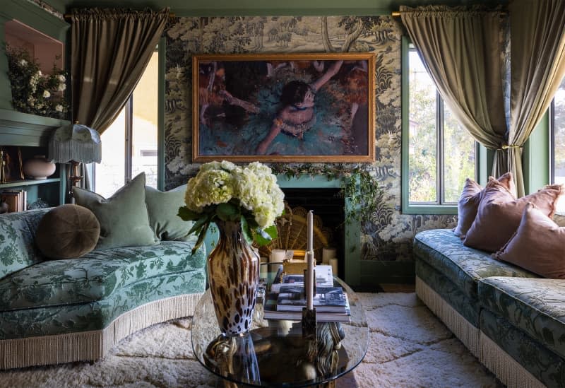 Living room layered with floral wallpaper, floral brocade sofa and cream shag rug.