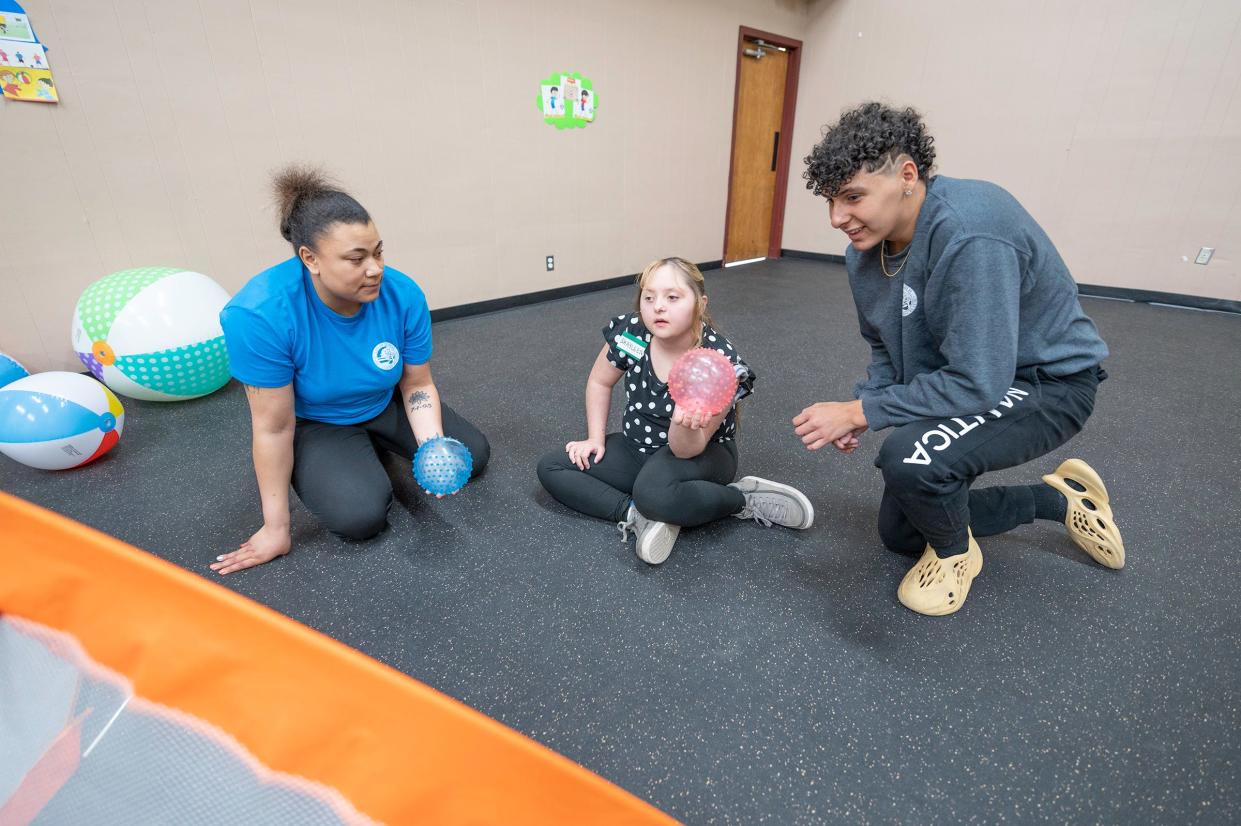 Recreation Lead Shamari Lewis, left, and Recreation Aide Andres Gloria, right, play with Shayleen Trujillo during "Inclusion Hour" at El Centro Del Quinto Sol recreation center on Friday.