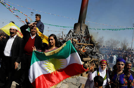 People gesture during a gathering celebrating Newroz, which marks the arrival of spring and the new year, in Diyarbakir, Turkey March 21, 2018. REUTERS/Umit Bektas