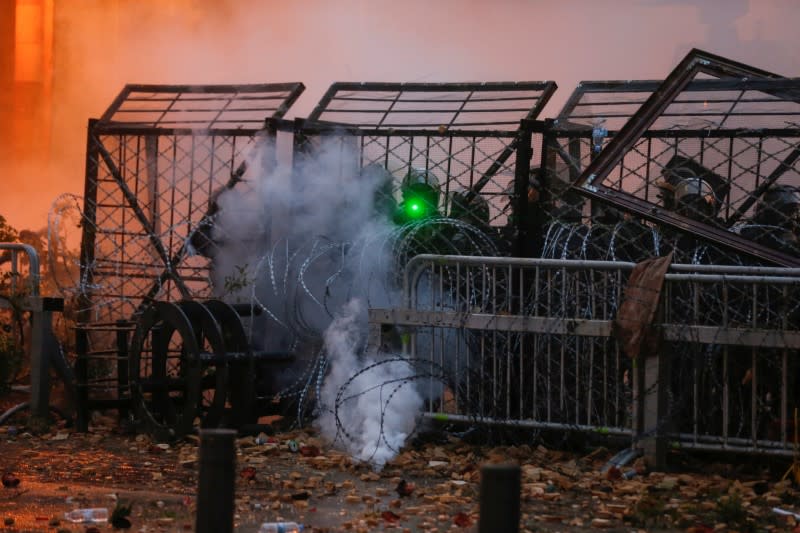 Lebanese security forces stand behind the barbed wire during a protest against a ruling elite accused of steering Lebanon towards economic crisis in Beirut